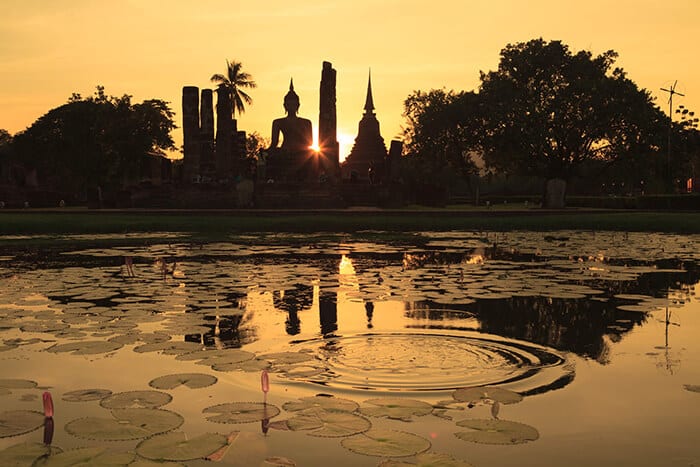 silhouette-of-ancient-buddha-statue-and-pagodas-against-sunset-sky-at-sukhothai-thailand-(sukothai)