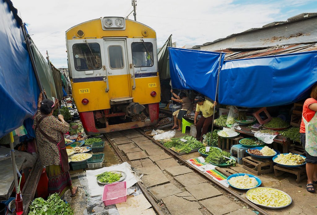 train-passes-by-the-mae-klong-railway-tracks-market-in-samut-songkram-thailand-100119117